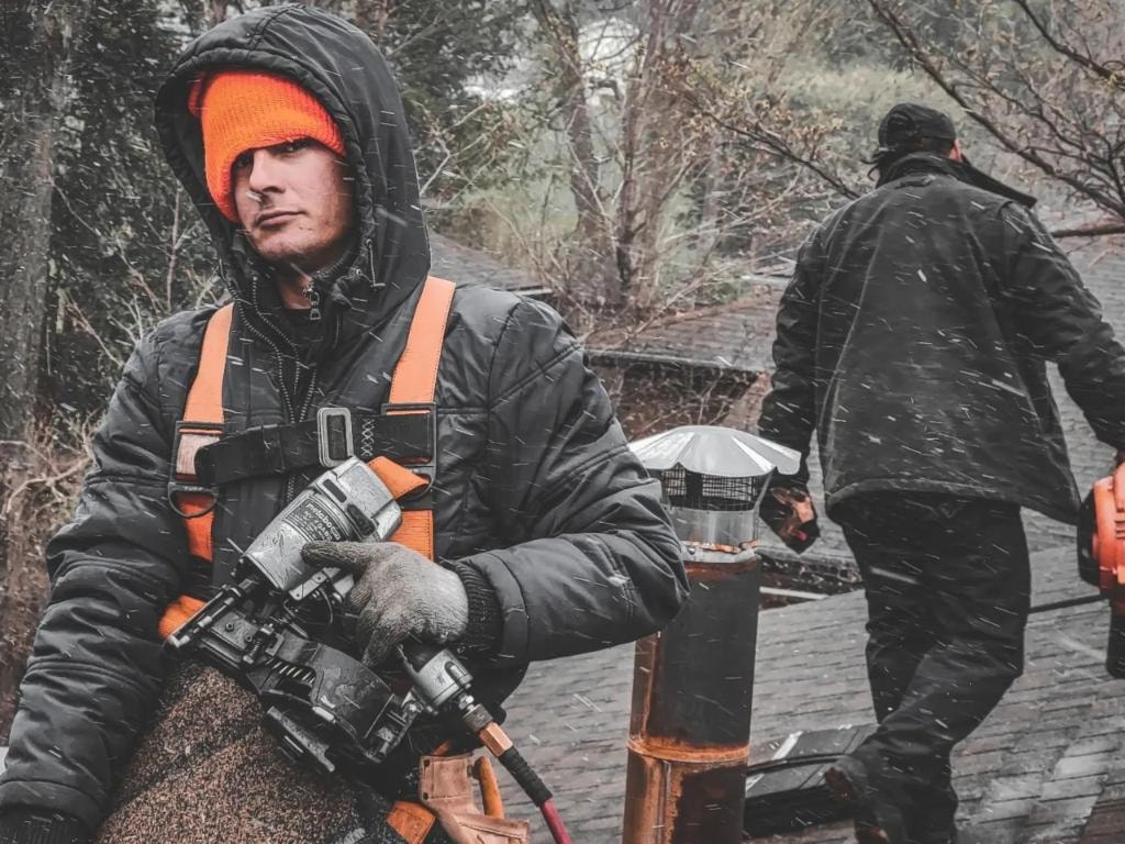 North Guard roofer with nail gun working in winter conditions
